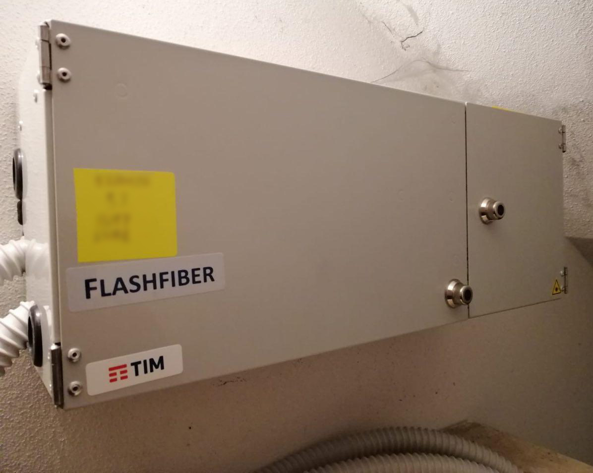Scatola di un ROE larga e bassa, fissata su una parete, con le etichette Flash Fiber e TIM